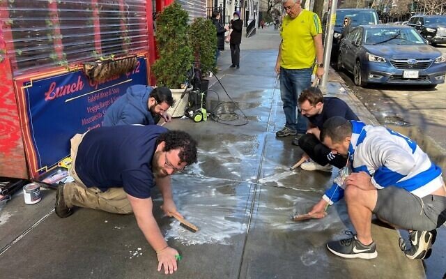 On their hands and knees, a group of Jewish volunteers scrub pro-Palestinian graffiti from the sidewalk outside of Effy's Café, a kosher restaurant on the Upper West Side, March 17, 2024. (Jackie Hajdenberg/JTA) On their hands and knees, a group of Jewish volunteers scrub pro-Palestinian graffiti from the sidewalk outside of Effy's Café, a kosher restaurant on the Upper West Side, March 17, 2024. (Jackie Hajdenberg/JTA)