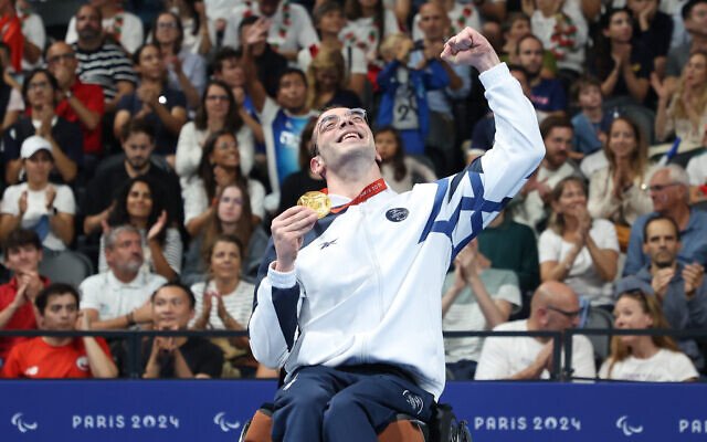Israeli Paralympian swimmer Ami Dadaon holds his gold medal at the Paris Games on August 30, 2024. (Lilach Weiss Rosenberg)