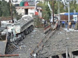 A picture taken from Lebanon shows Syrian officials inspecting the damage on the Syrian side of the Dabussiyeh border crossing after an Israeli airstrike on November 27, 2024. (Fathi AL-MASRI / AFP)