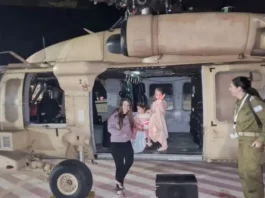 Aviv Asher, 2.5 years old, her sister Raz Asher, 4.5 years old, and mother Doron, react as they step off an Israeli military helicopter, shortly after their arrival in Israel on November 24, after being held hostage by Hamas in Gaza