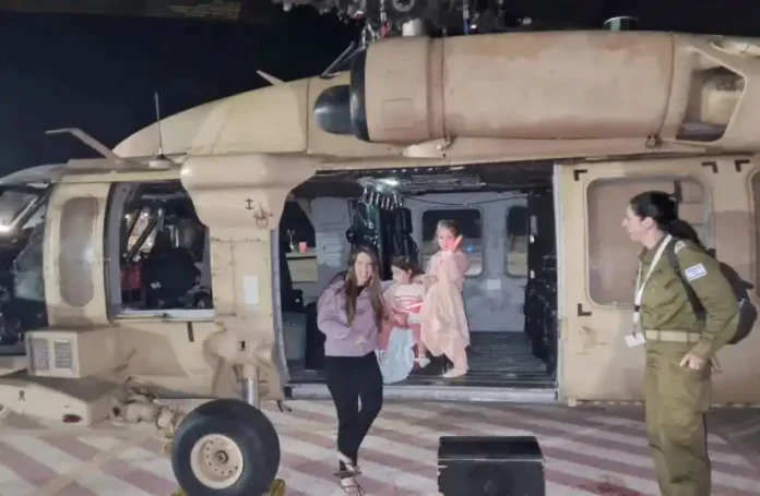 Aviv Asher, 2.5 years old, her sister Raz Asher, 4.5 years old, and mother Doron, react as they step off an Israeli military helicopter, shortly after their arrival in Israel on November 24, after being held hostage by Hamas in Gaza