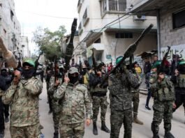 Hamas militants carry arms at funeral of senior commander killed in Israeli airstrike, February 2025