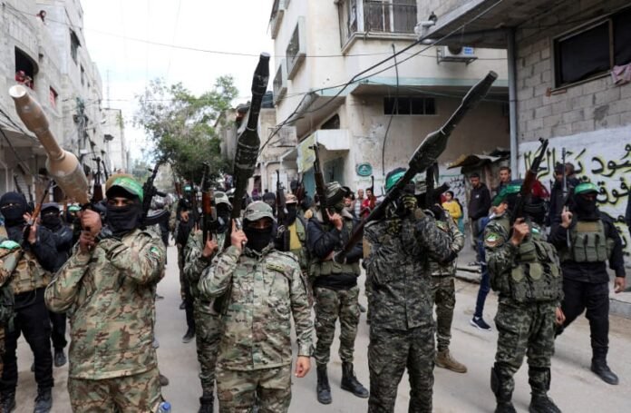 Hamas militants carry arms at funeral of senior commander killed in Israeli airstrike, February 2025