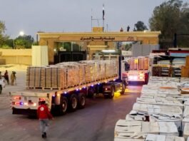 Palestinian Hamas terrorists stand guard during a hostage handover in Rafah, reflecting ongoing security tensions in southern Gaza