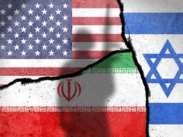 An Iranian woman stands before an anti-US mural during the 46th anniversary of the U.S. expulsion from Iran in Tehran