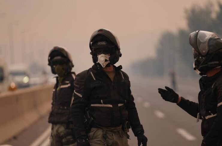 Firefighters and medics operate outside a residential building in Ashkelon following an apartment fire amid severe storm conditions